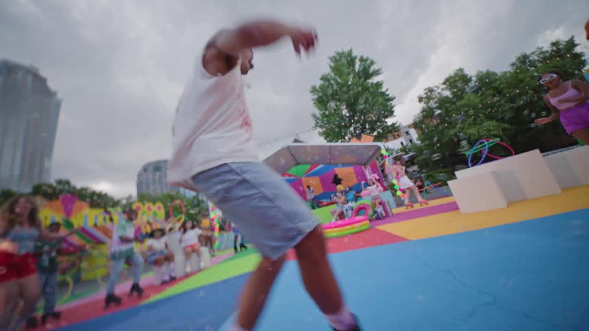 Group of people in an openair playground with people dancing and rollerblading