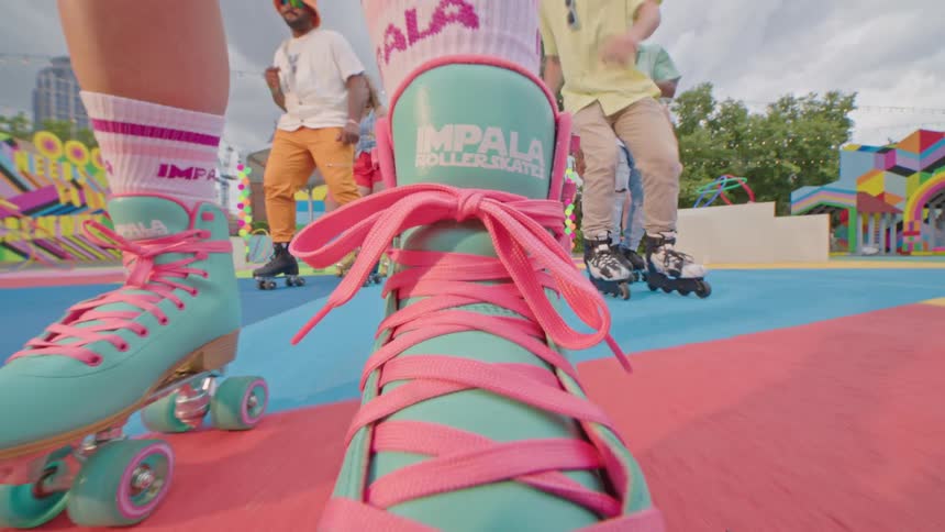 Close up of a persons legs rollerblading on a colorful playground
