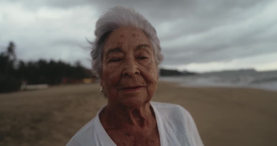 Portrait of an elderly lady on the beach sand