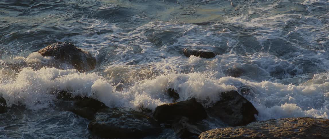 Waves crash on the rocks of the shore
