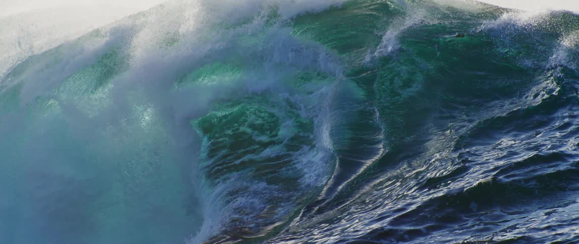 Powerful wave in the ocean begins to curve and explodes loudly