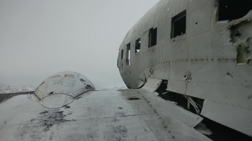 Old abandoned plane wreck with missing windows sits on field on a winter day
