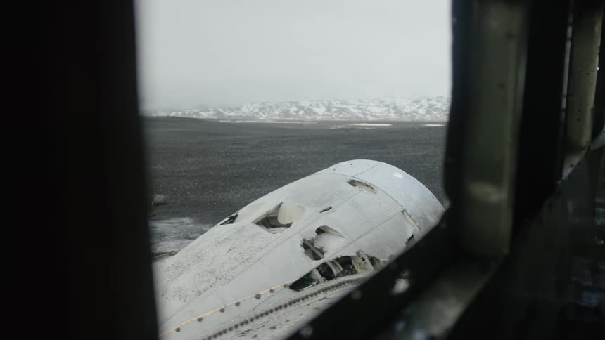 Wreckage of a plane is seen through an open window
