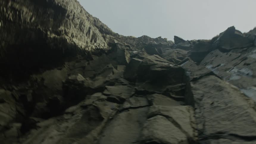A steep mountain cliff visible from the ground