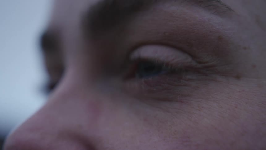 A woman is blinking her eyes