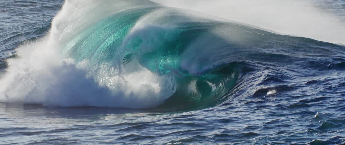 The sun is reflecting on the crashing waves