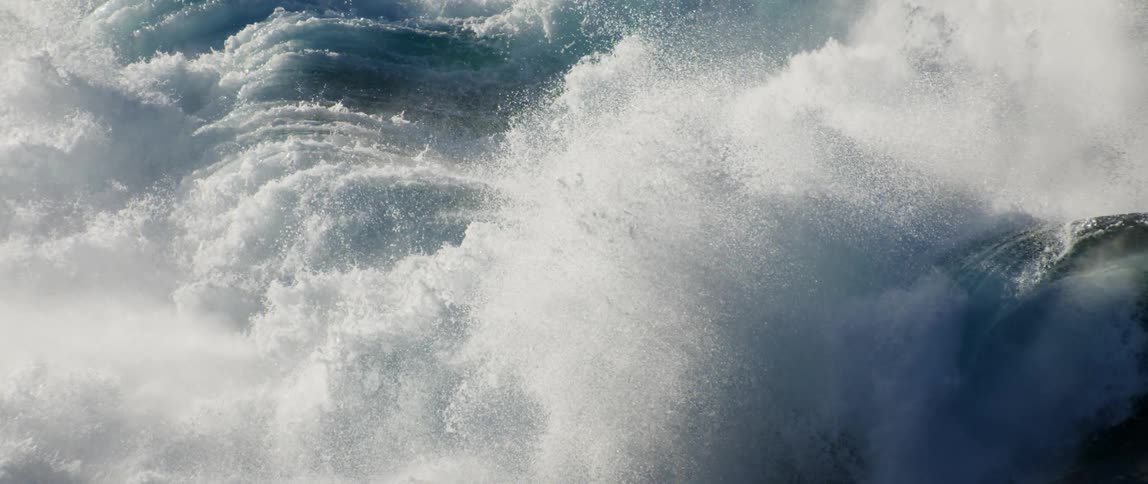Mist flies everywhere as the waves crash