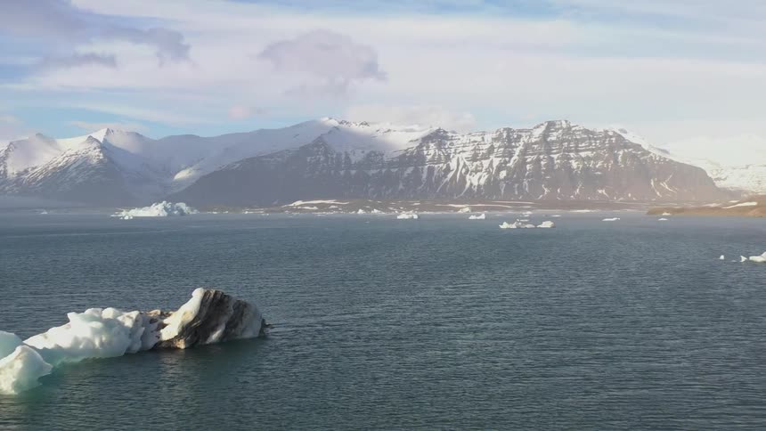 Icebergs are in the water by the mountain