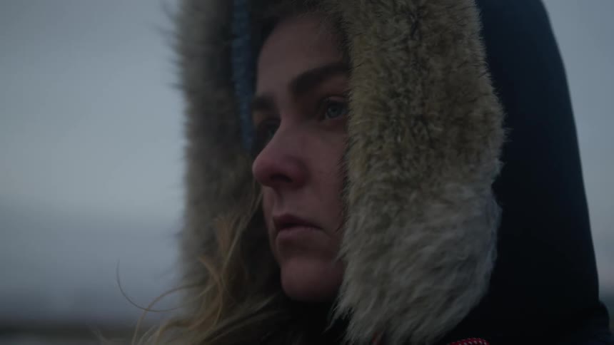 Portrait of a young woman with a jacket and hood and an outdoor setting