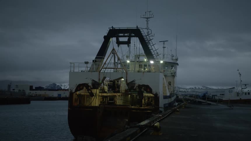 Industrial ship docked in a port during dawn