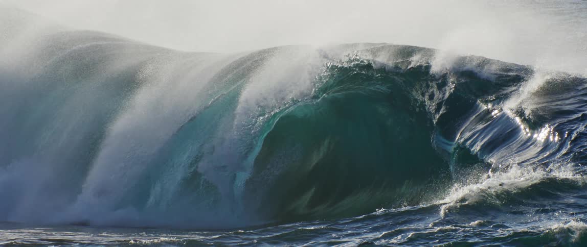 The sun reflects off the crashing waves