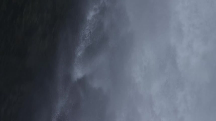 A massive waterfall drops water down the side of a mountain