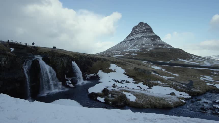 Natural landscape with a waterfall and an imposing snowy mountain in the background