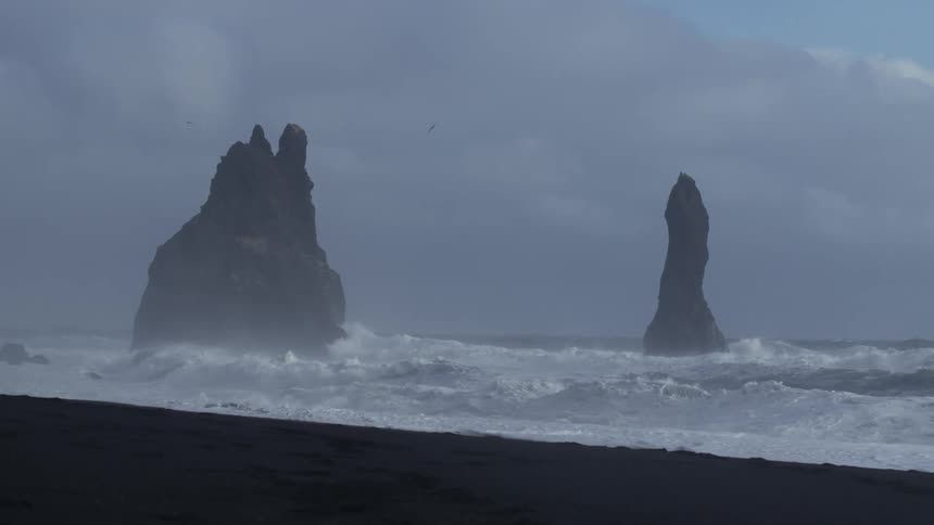 Misty seascape with two prominent rock formations emerging from the ocean