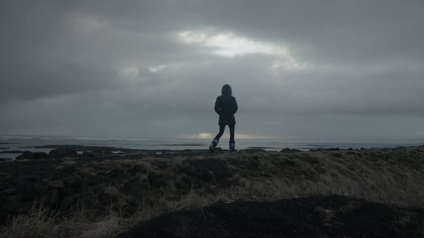 A woman walks past the shore
