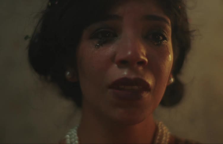 People walk past a woman crying