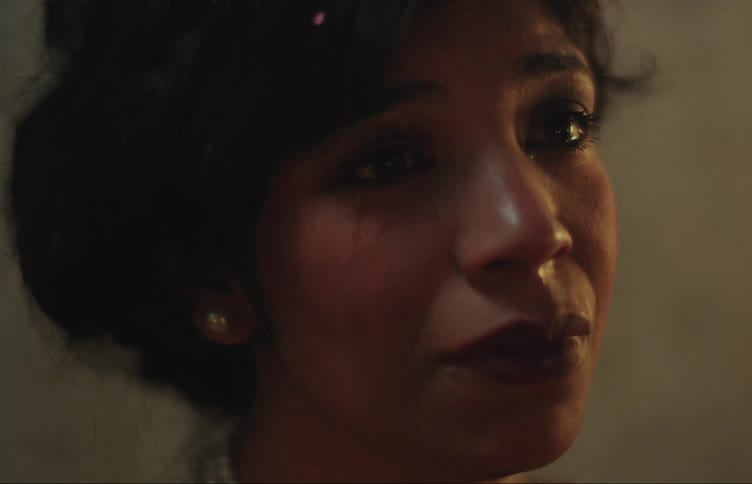 Close up of the face of a sad woman crying in a dimly lit room