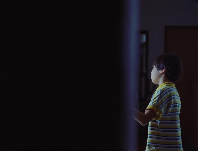 Boy with one hand on the wall inside the house