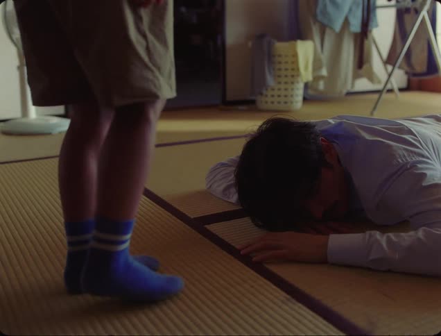 Man lying on the floor with a childs legs in front of him