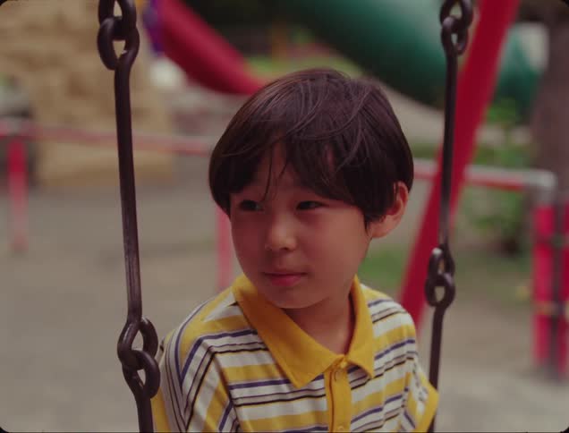Portrait of a boy sitting on a toy in the park happily