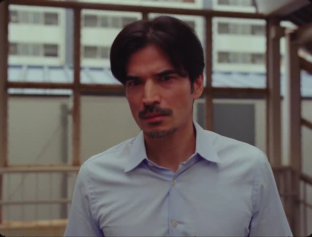 A man walks up stairs and moves forward despite looking fearful