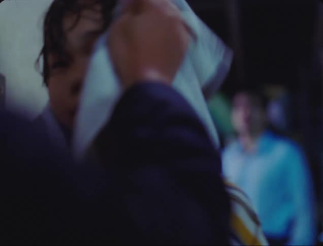 A man dries a young asian boys head with a towel while another man watches in sadness