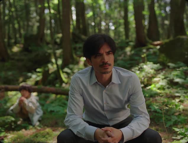 Thoughtful father sitting in a forest and his son in the background playing