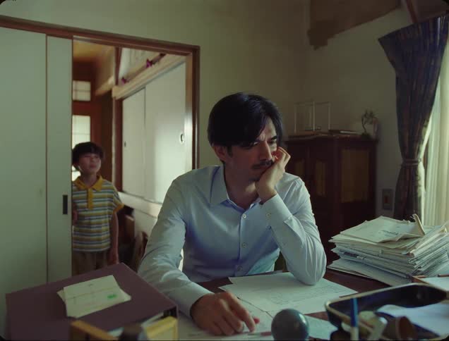 A father gets up in his office to confront his young son at the door