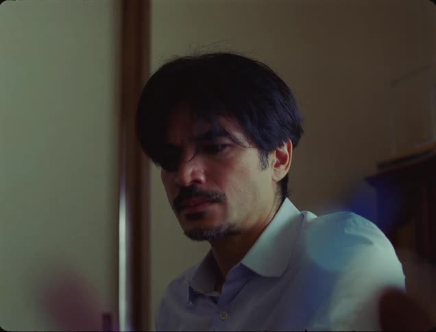 Man sitting in an indoor space and looking sad
