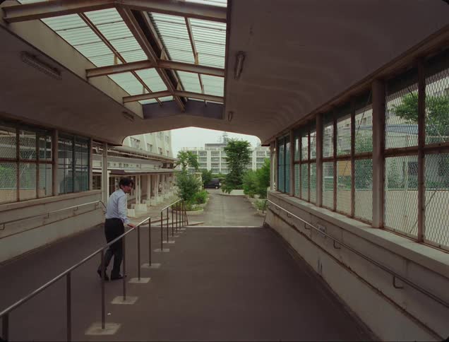 A man walks along with a child followed closely by a creepy person stalking them