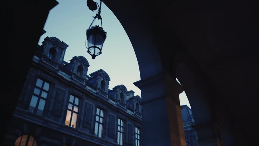 Windows of a palace through stone arches at the Louvre in Paris