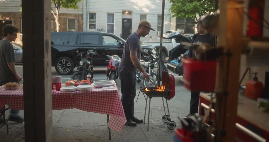 Someone is grilling outdoors flames rising from the barbecue on the neighborhood streets