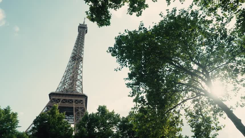 The eiffel tower viewed from a low angle stands against a clear sky in Paris