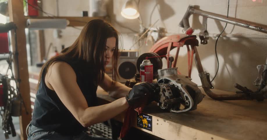 Female mechanic cleaning an automotive part