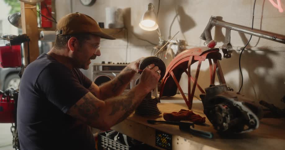 Man working on an automotive part with the aid of tweezers