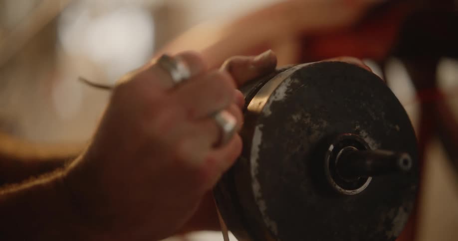 Portrait of a concentrated man using tweezers on an automotive part