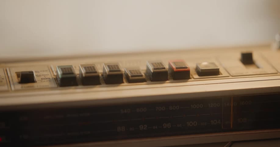 Hand with a black glove clicking the button of a vintage device