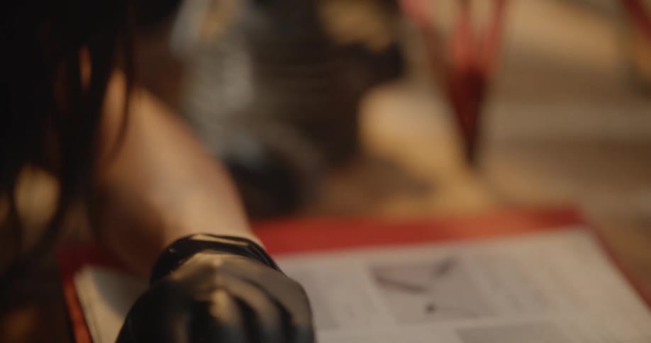 Portrait of a concentrated woman wearing black gloves reading