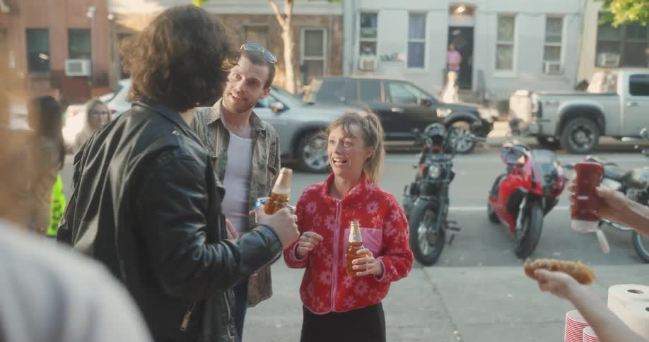 Friends enjoy themselves while cooking outdoors near a residential street