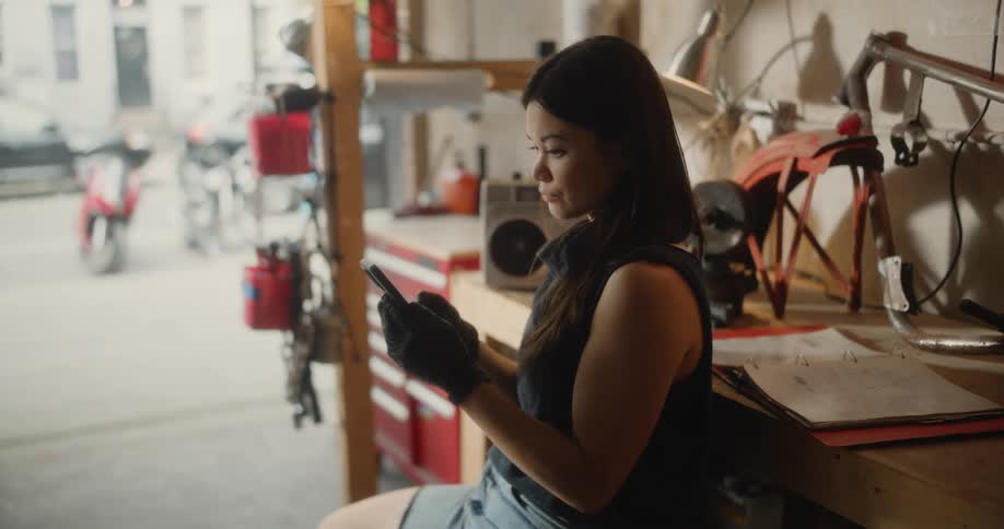 A woman is using her cell phone in the garage