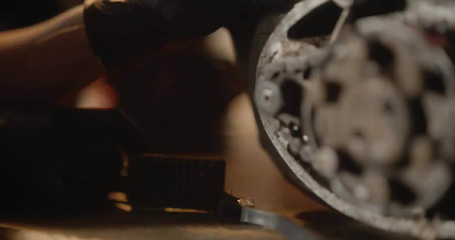 A person turns on the radio and works on a motor