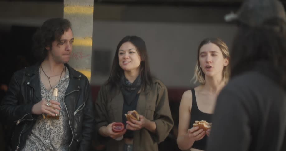 A group of young adults enjoying burgers and drinks in a casual setting
