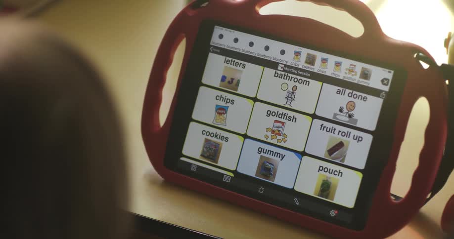 Child focused on a toy displaying an educational screen