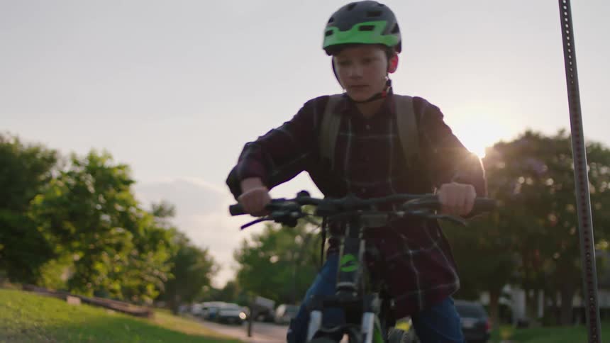 Boy wearing a helmet sitting on a bicycle and starting to pedal