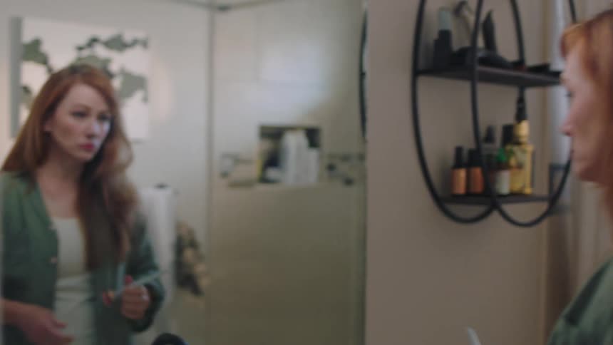 Woman going to the bathroom and putting on makeup in front of the mirror
