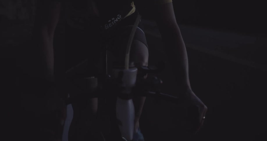 Cyclist riding on a highway with the silhouette of mountains in the background