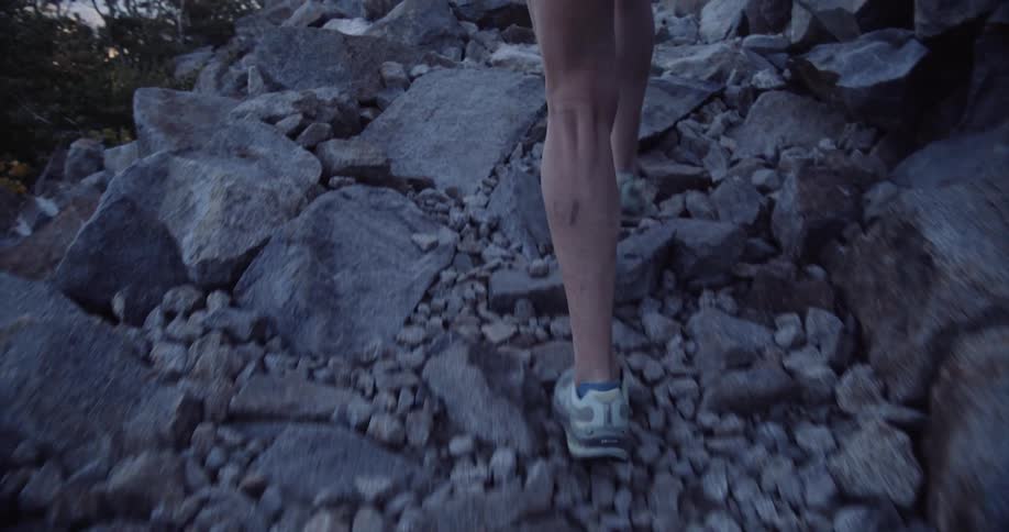 A person running up a steep rocky trail