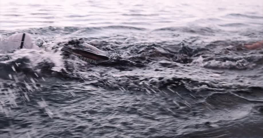 Person with clothes and cap swimming