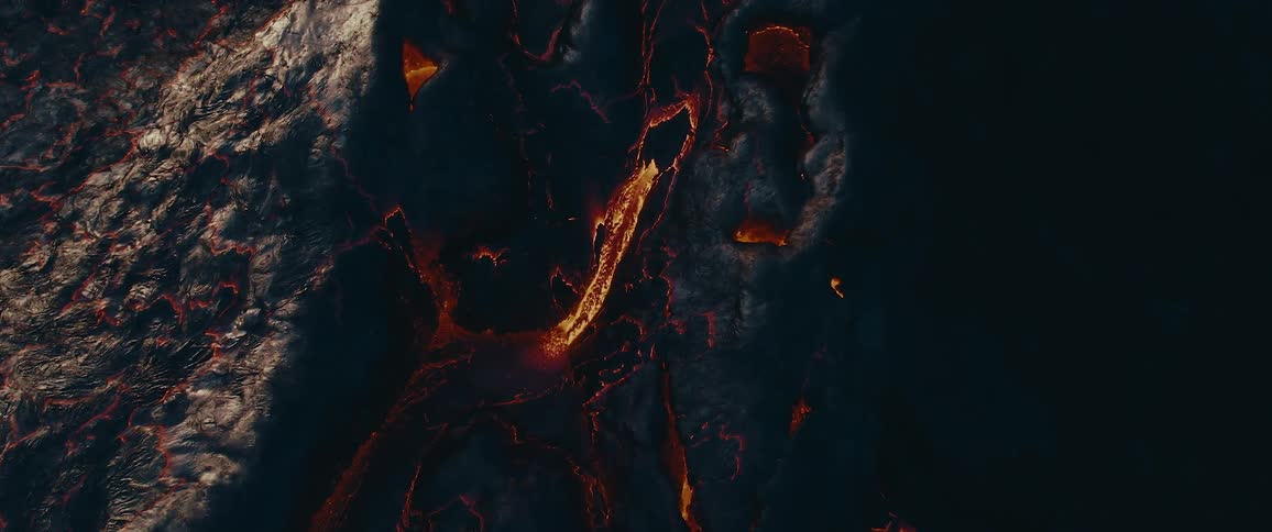 An aerial view of a volcanic eruption with lava flowing from the crater
