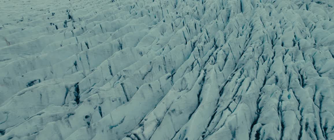 Arctic aerial panorama of glaciers and mountains with snow on the horizon